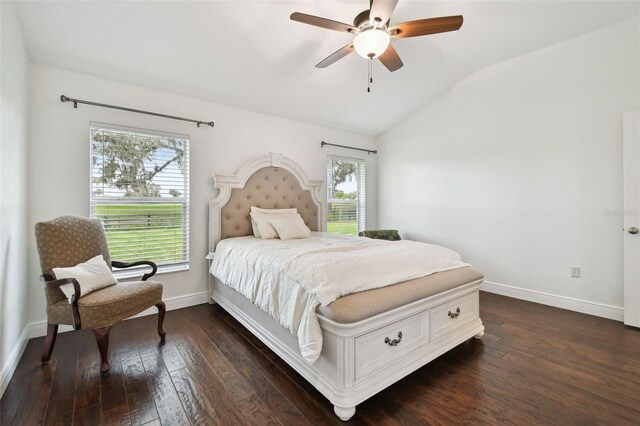 bedroom featuring multiple windows, dark hardwood / wood-style flooring, vaulted ceiling, and ceiling fan