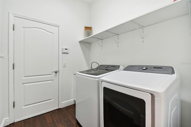 laundry area with dark hardwood / wood-style flooring and washer and dryer