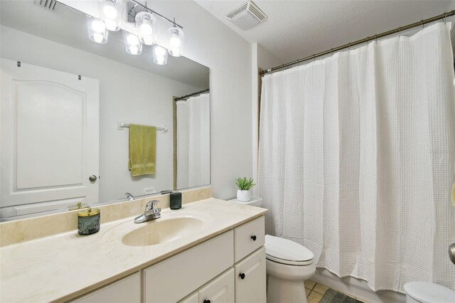 full bathroom featuring vanity, shower / bath combo, tile patterned floors, and toilet