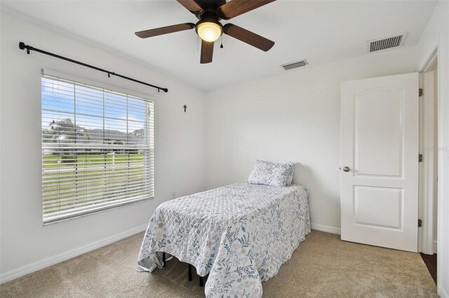 bedroom featuring light colored carpet and ceiling fan