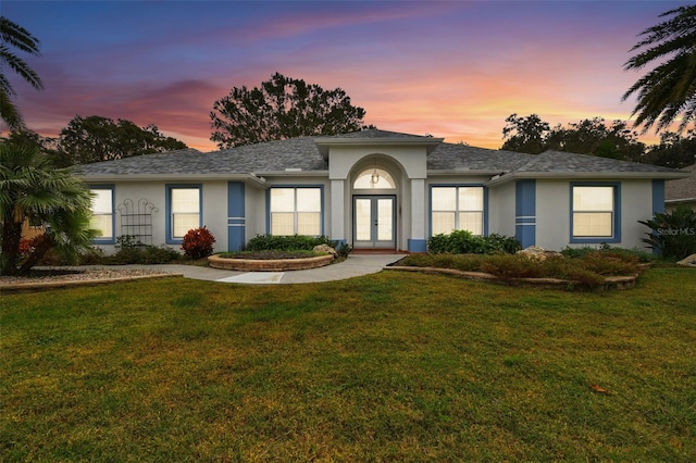 view of front of house featuring a lawn and french doors