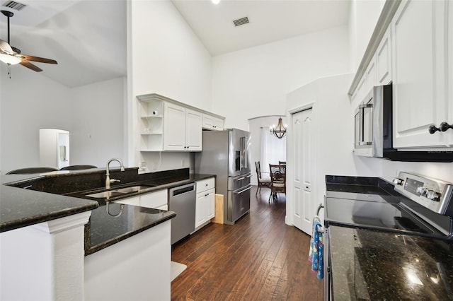 kitchen featuring stainless steel appliances, sink, dark stone countertops, and white cabinets