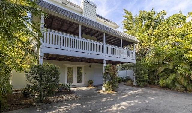 view of front of house with french doors and a balcony