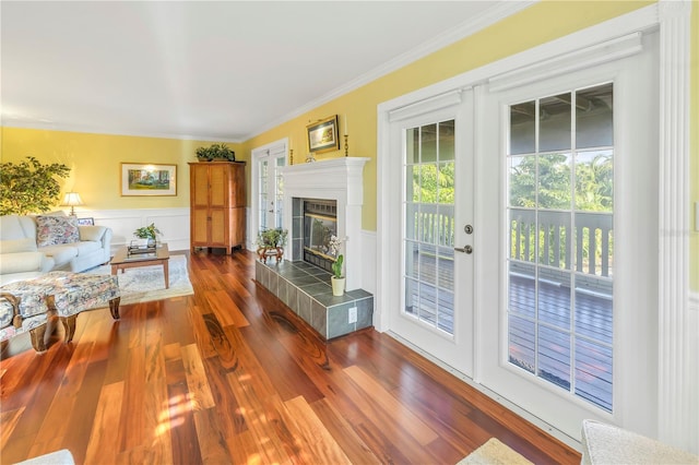 living room featuring ornamental molding, a fireplace, and dark wood-type flooring