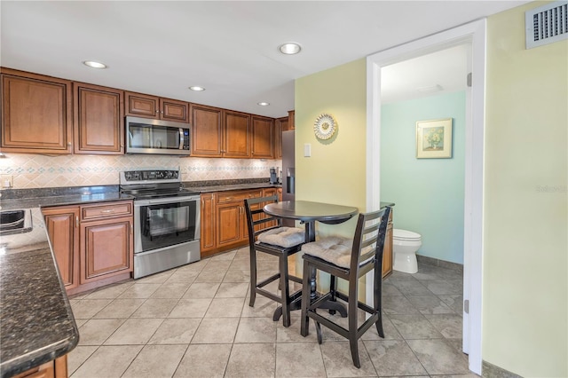 kitchen with decorative backsplash, light tile patterned floors, sink, and appliances with stainless steel finishes