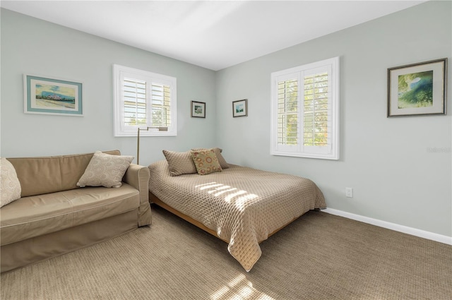 bedroom featuring light colored carpet and multiple windows