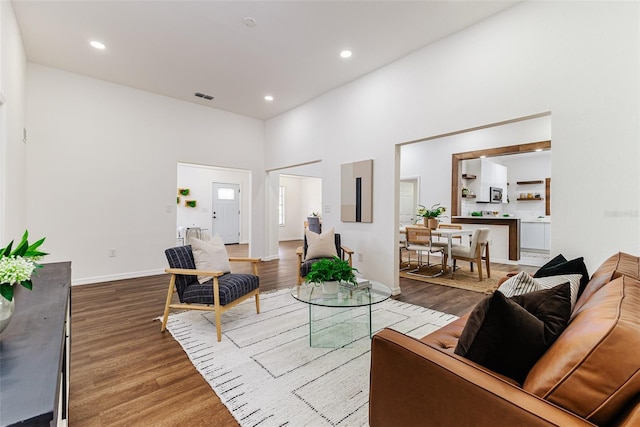 living room featuring a high ceiling and hardwood / wood-style floors