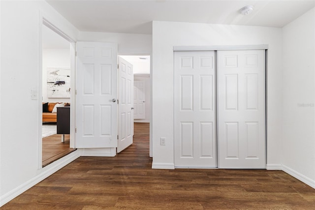 unfurnished bedroom featuring dark hardwood / wood-style flooring and a closet