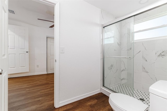 bathroom featuring toilet, wood-type flooring, ceiling fan, and a shower with shower door