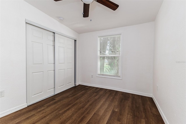 unfurnished bedroom with dark hardwood / wood-style flooring, ceiling fan, and a closet