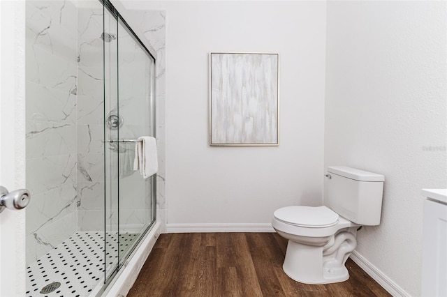 bathroom with toilet, hardwood / wood-style floors, and a shower with shower door