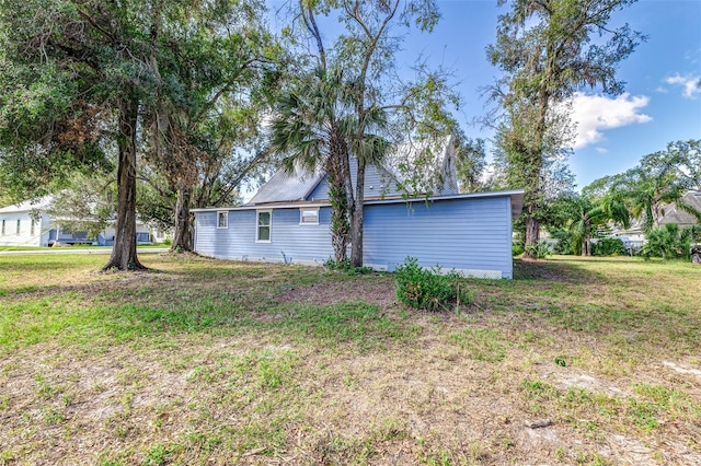 view of side of home with a yard