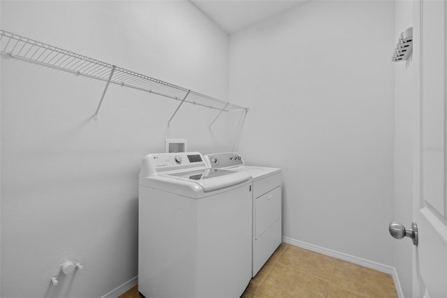 clothes washing area with light tile patterned floors and independent washer and dryer