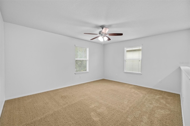 spare room featuring ceiling fan, a healthy amount of sunlight, and carpet floors