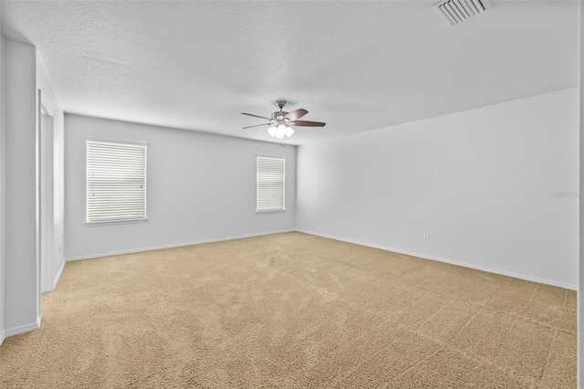 carpeted spare room featuring ceiling fan and a textured ceiling