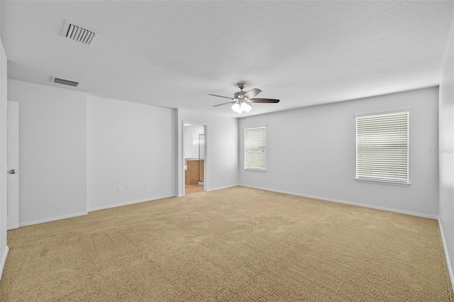 carpeted empty room with a textured ceiling and ceiling fan