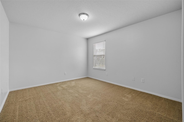 carpeted empty room featuring a textured ceiling