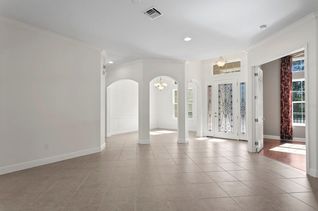 tiled spare room with an inviting chandelier and ornamental molding