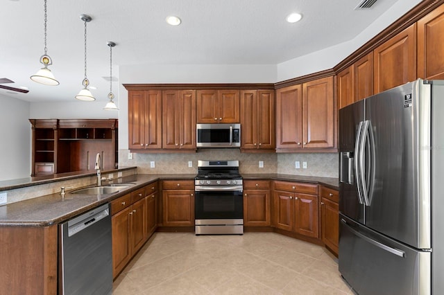 kitchen featuring sink, stainless steel appliances, tasteful backsplash, kitchen peninsula, and pendant lighting