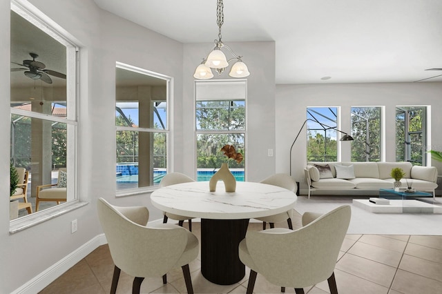 tiled dining area featuring ceiling fan with notable chandelier