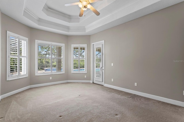 carpeted empty room with a tray ceiling, ceiling fan, and crown molding