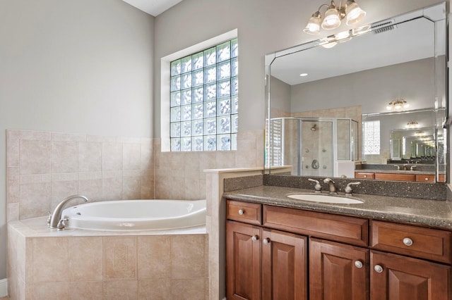 bathroom with plus walk in shower, vanity, and an inviting chandelier