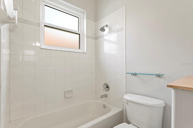 bathroom featuring toilet and tiled shower / bath