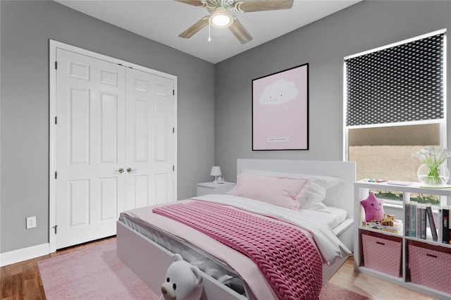 bedroom with hardwood / wood-style floors, a closet, and ceiling fan