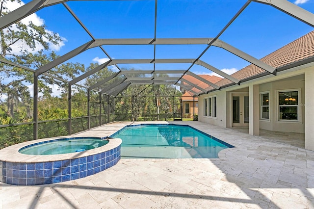 view of pool featuring glass enclosure, an in ground hot tub, and a patio