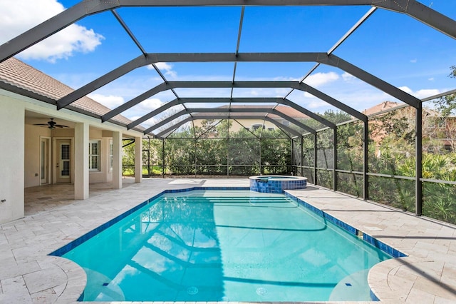 view of pool with a lanai, ceiling fan, a patio area, and an in ground hot tub