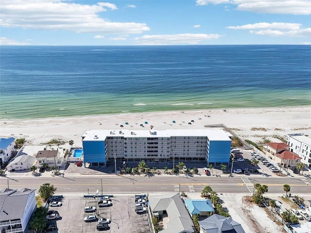 birds eye view of property with a water view and a beach view