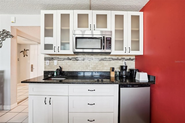 kitchen with sink, white cabinets, stainless steel appliances, and a textured ceiling