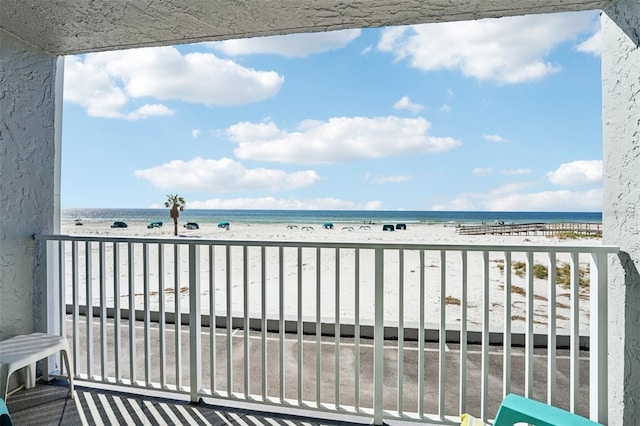 balcony featuring a beach view and a water view