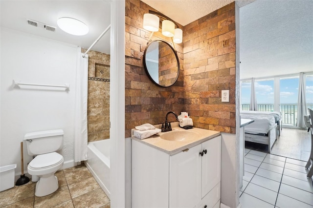 full bathroom featuring tile patterned floors, a textured ceiling, toilet, vanity, and shower / tub combo