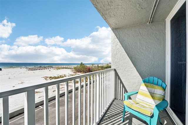 balcony featuring a beach view and a water view