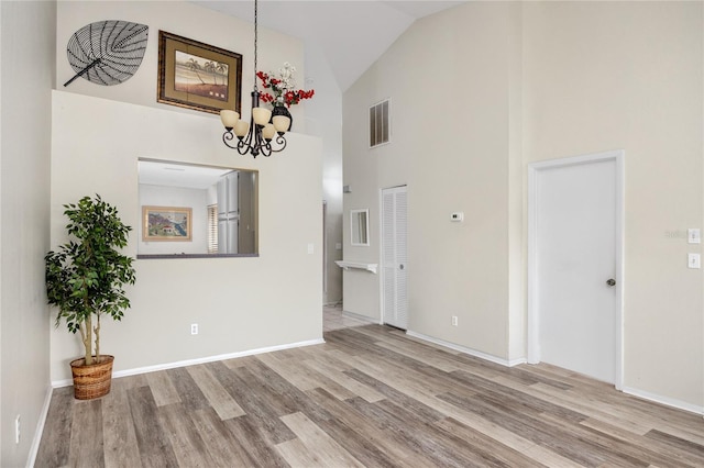 unfurnished room featuring an inviting chandelier, visible vents, and light wood-style floors