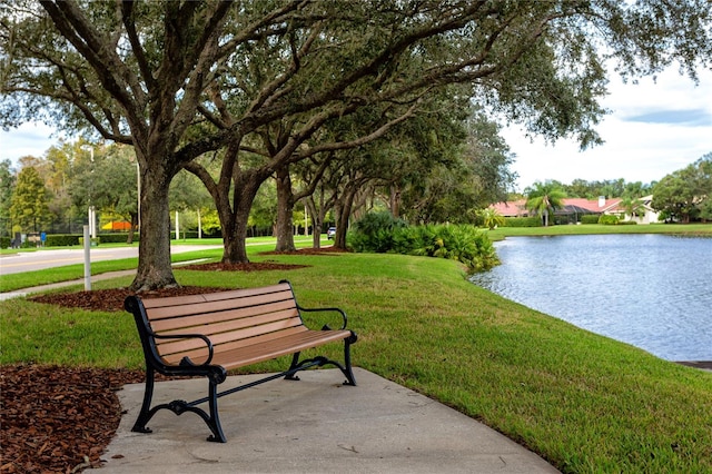 surrounding community featuring a lawn and a water view