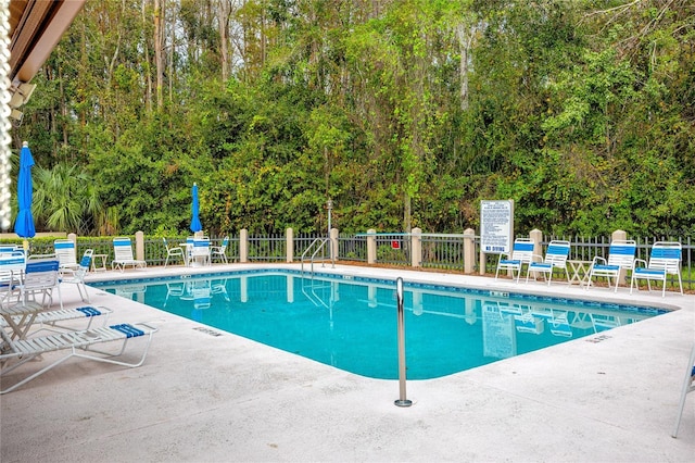 pool featuring a patio area and fence