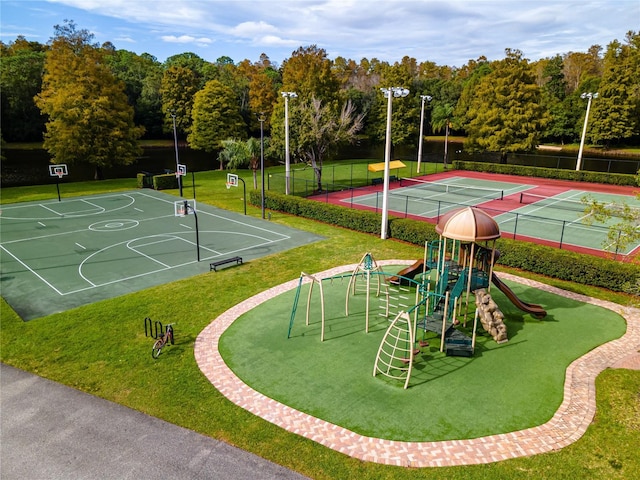 exterior space with a tennis court, community basketball court, a yard, and fence