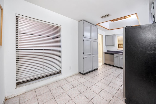 kitchen with light tile patterned floors, stainless steel appliances, visible vents, and gray cabinetry