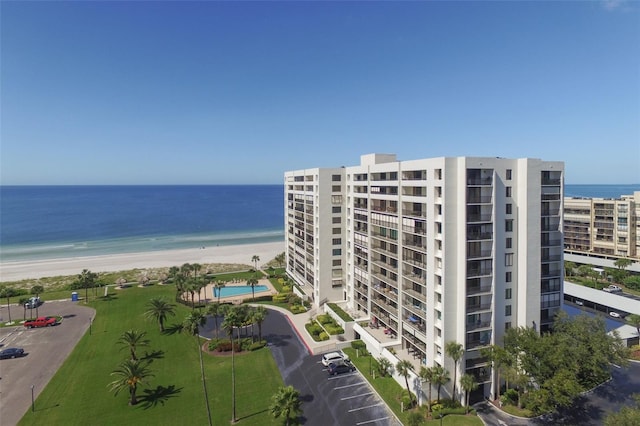 view of property with a water view and a beach view