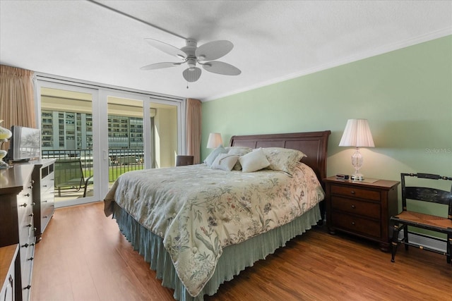 bedroom featuring hardwood / wood-style flooring, crown molding, expansive windows, and access to outside