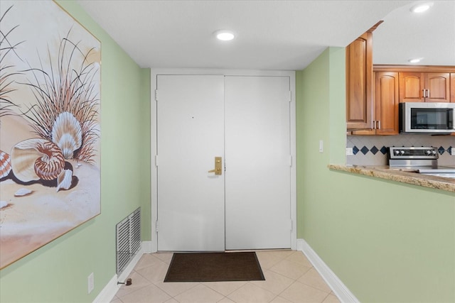 doorway to outside with light tile patterned floors