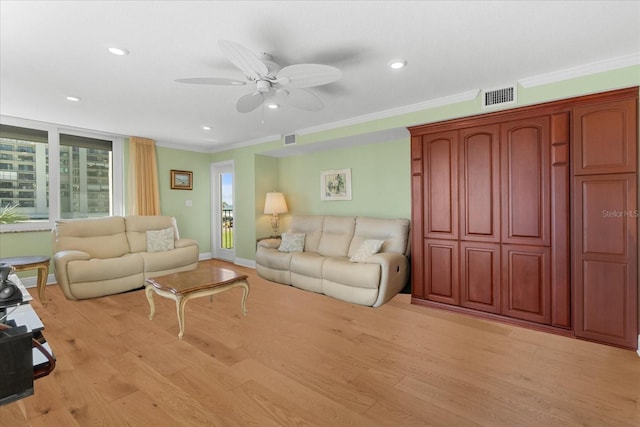 living room with ornamental molding, ceiling fan, and light wood-type flooring