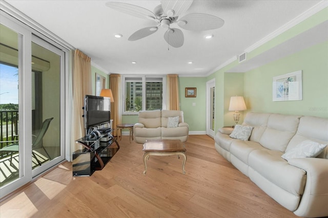 living room featuring ornamental molding, a wealth of natural light, and light hardwood / wood-style flooring