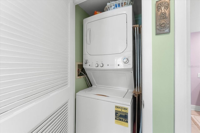 clothes washing area featuring stacked washer and dryer