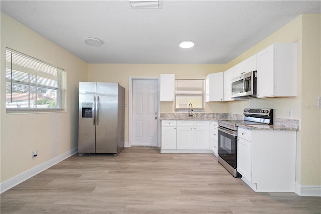 kitchen featuring white cabinetry, appliances with stainless steel finishes, and light hardwood / wood-style flooring