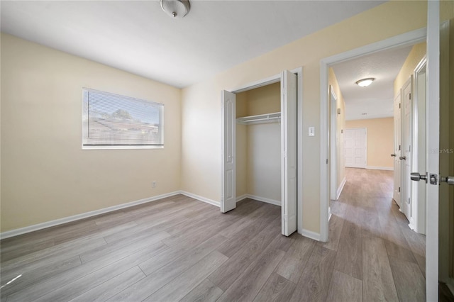 unfurnished bedroom featuring a closet and light hardwood / wood-style floors