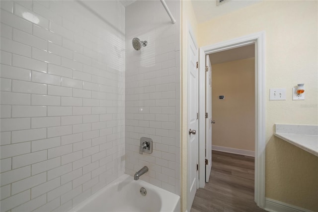 bathroom featuring tiled shower / bath combo and wood-type flooring