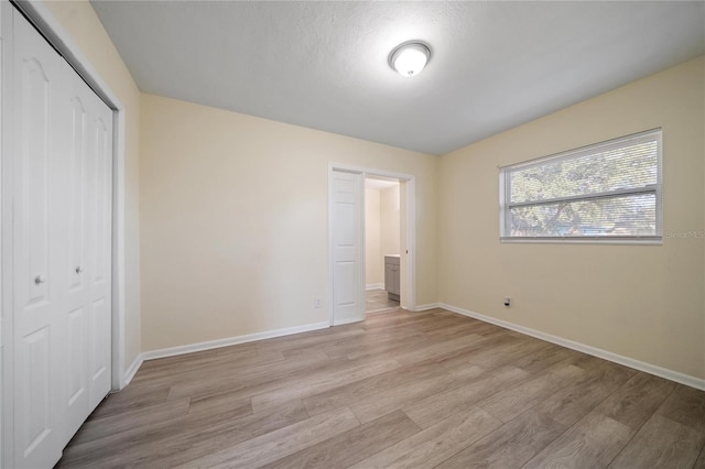 unfurnished bedroom with a closet and light hardwood / wood-style flooring